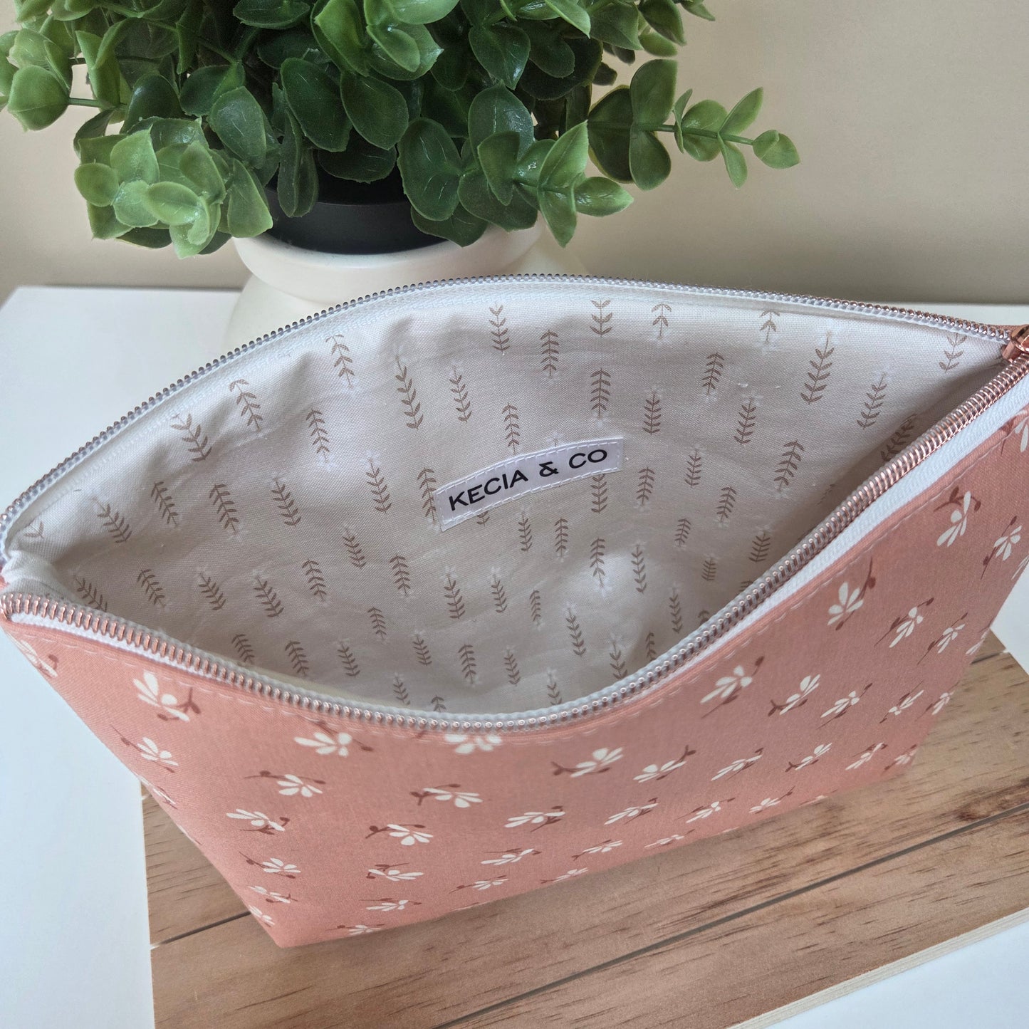 Interior view of the Clay Blossom zipper pouch with ivory lining and floral exterior
