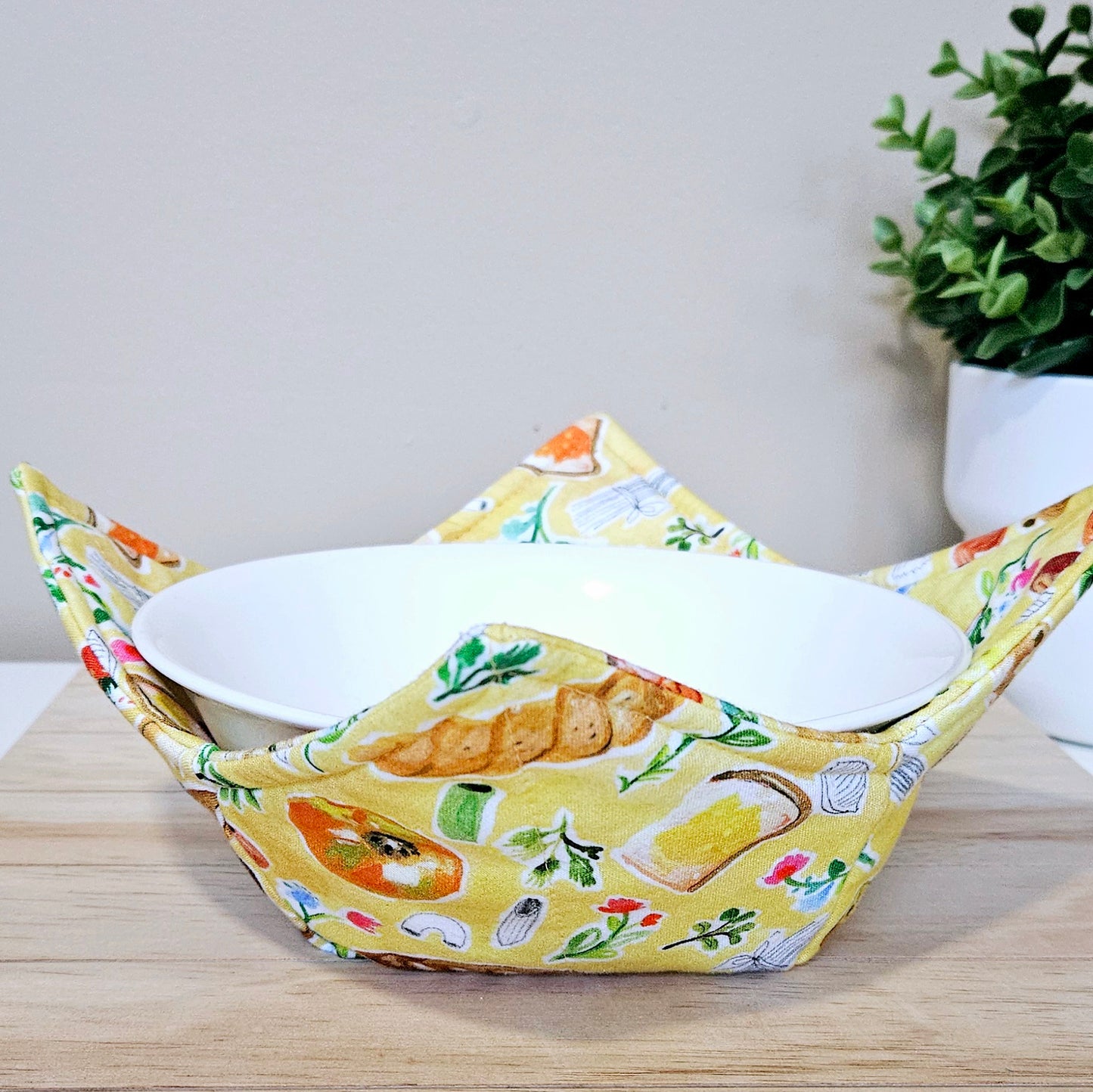 Handmade cotton bowl cozy with cozy carb-themed print featuring loaves, buns, and pastries