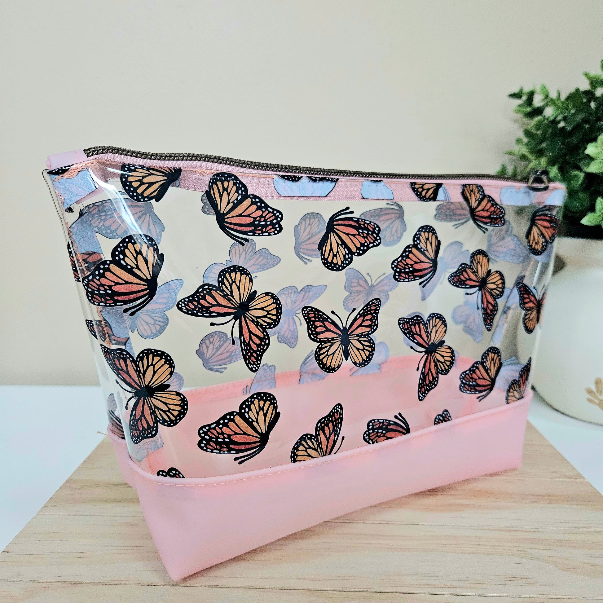 Clear butterfly travel pouch with pink base and zipper