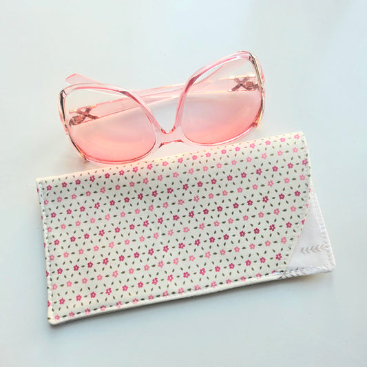 Pink sunglasses on a floral fabric case