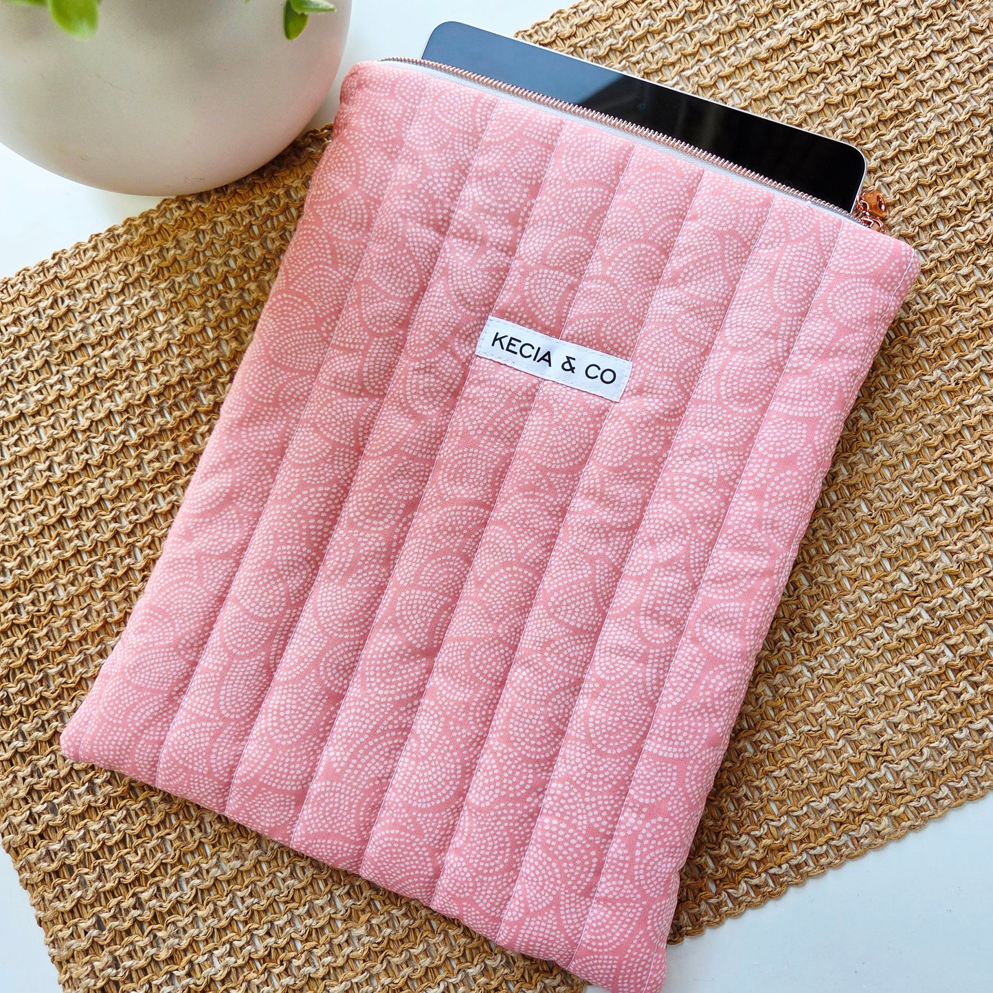 Zipper opening showing iPad inside blush pink quilted sleeve
