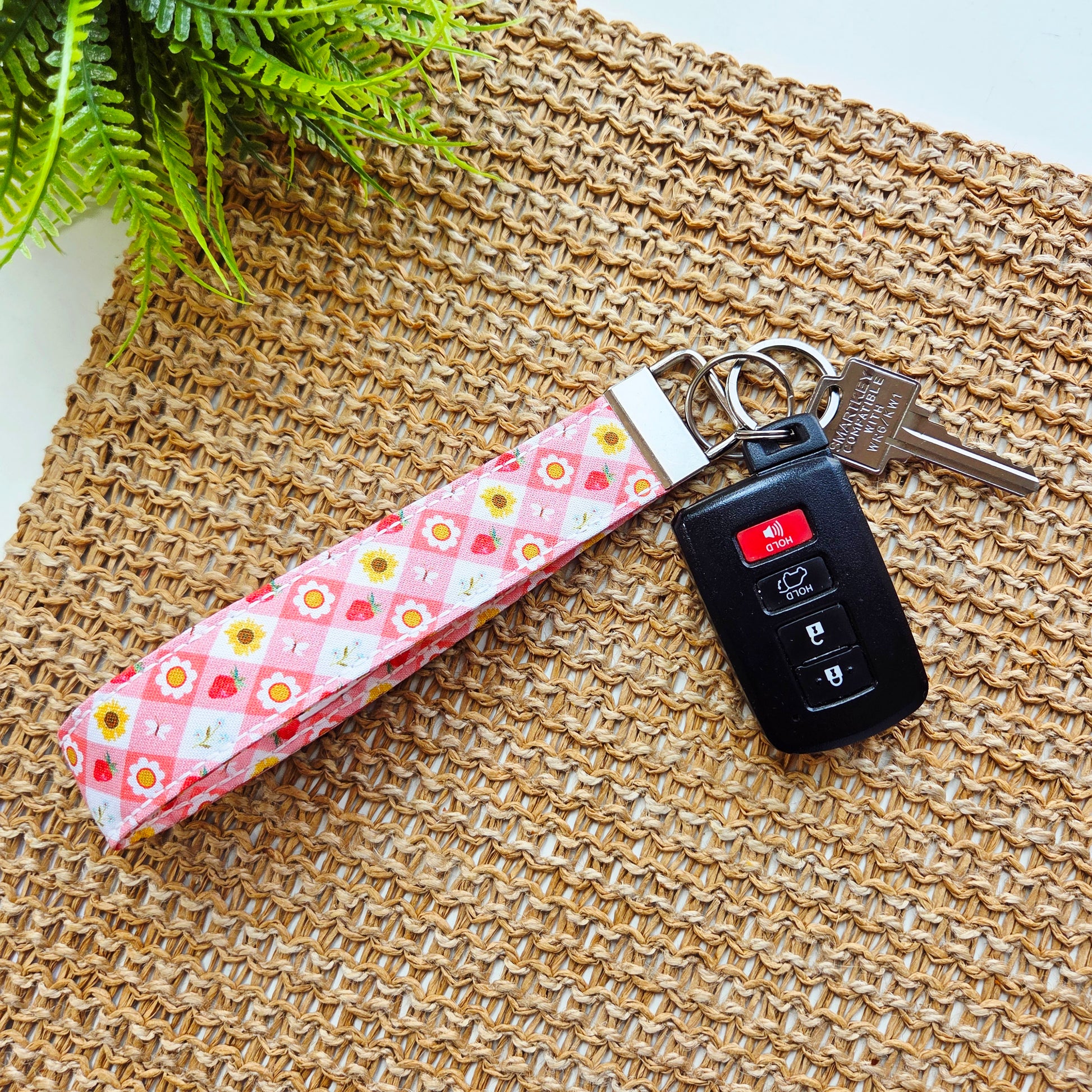 Handmade fabric keychain wristlet in pink Strawberry Picnic print with metal clip and key ring.